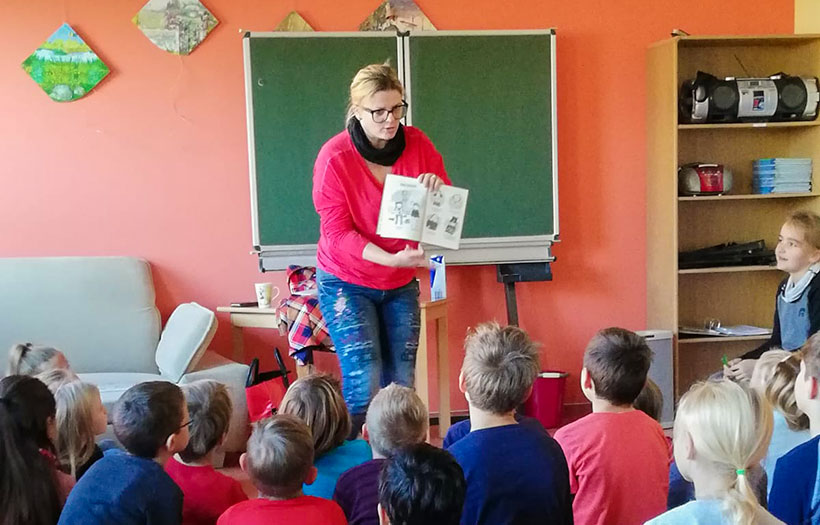 Lehrerin liest Grundschülern eine Geschichte vor