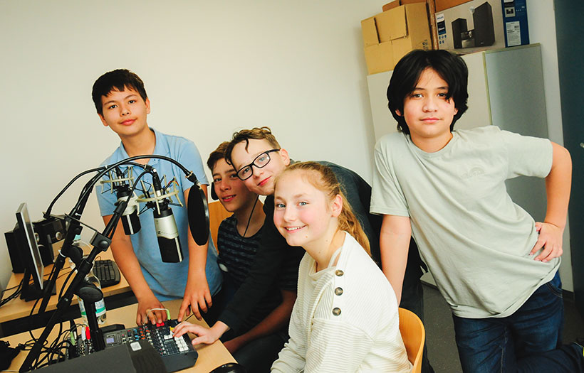 Kinder beim Aufnehmen eines Beitrags für das Schülerradio