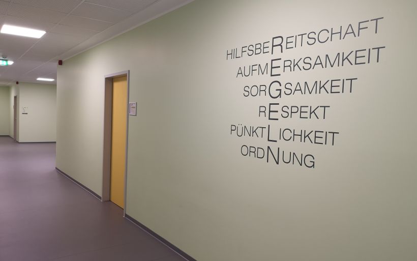 Ein Schriftzug an der Wand er Schule zeigt die Schulregeln. Foto: Caroline Lindner / DPFA Chemnitz
