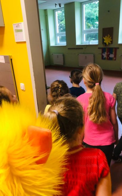 Kinder betreten ein Zimmer in einer Schule.