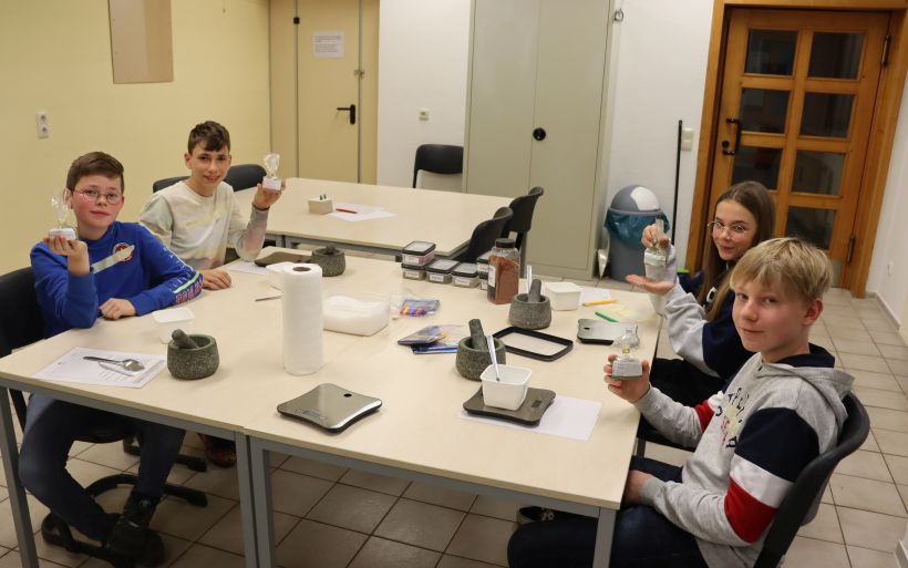 Vier Schüler zeigen ihre einzeln hergestellten Kräutersalze